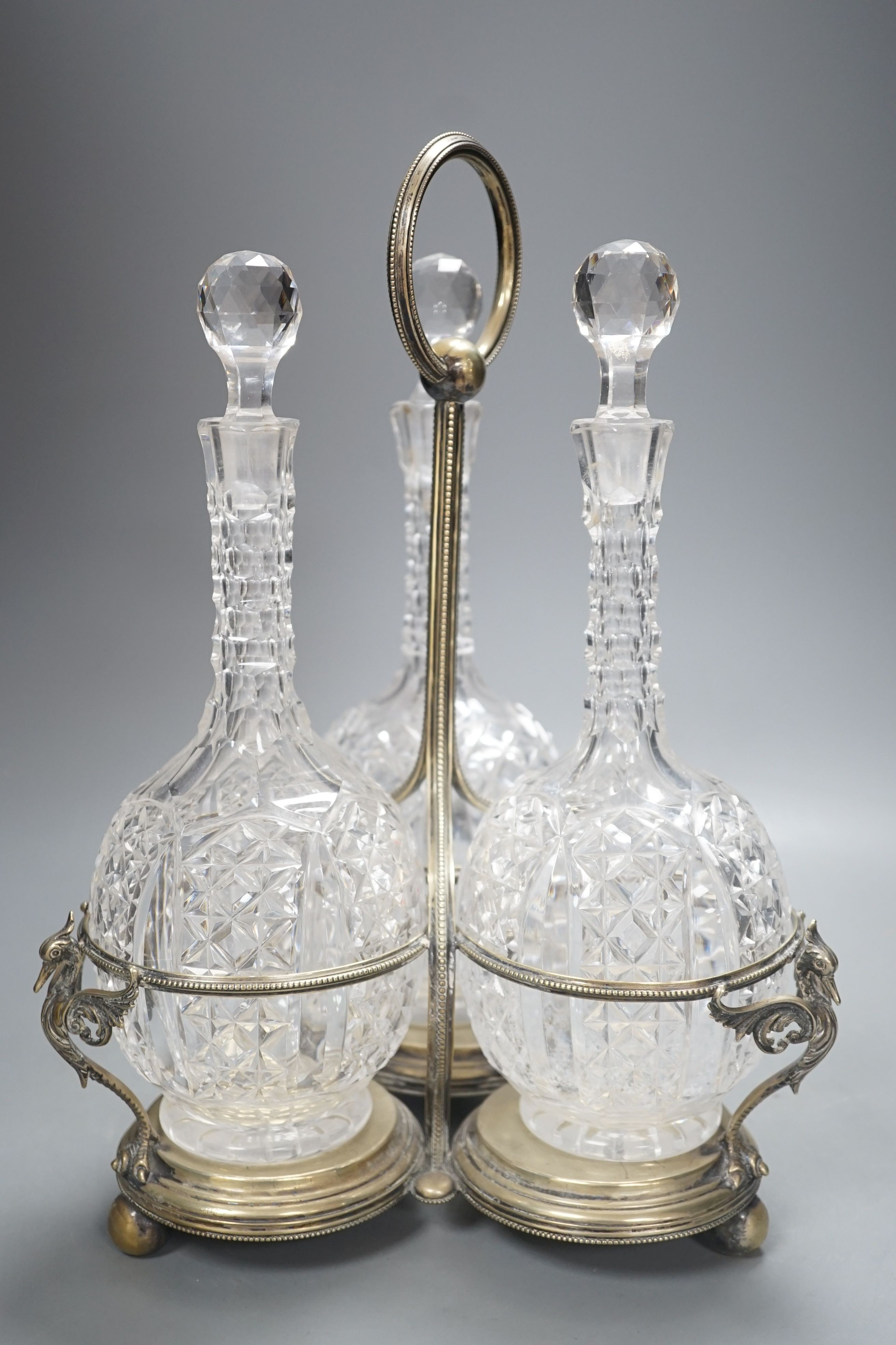 A Victorian plated decanter stand and three cut glass decanters, 34 cms high.